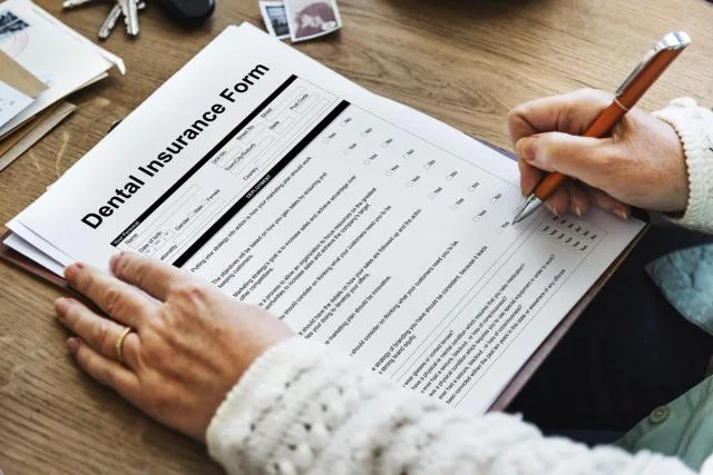 Patient completing a dental insurance form