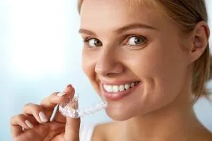 Patient holding a clear orthodontic aligner